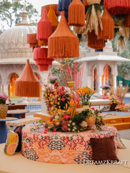 A custom-printed ottoman at the center of a lounge area, surrounded by oversized tassels hanging from the ceiling.