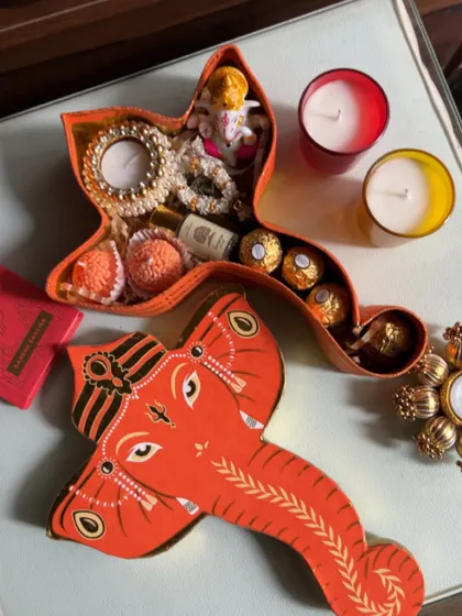 My Ganesh Chaturthi collection is all about unique and thoughtful designs. This special Ganesha-shaped box is filled with laddoos, Ferrero Rocher chocolates, a mini Ganesha idol, and a beautiful pearl-studded candle holder.