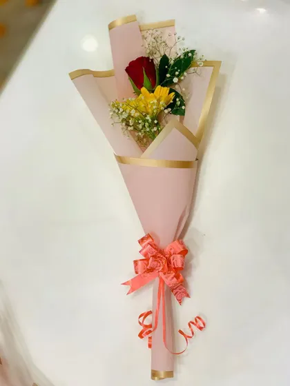 A sweet mini-bouquet with one red rose and one yellow gerbera daisy. The simple pink wrapping makes it a lovely, small token of appreciation.