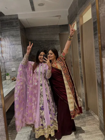 A fun mirror selfie with a friend at a 50th birthday celebration. I'm wearing a lilac floral Anarkali, a great choice for a celebratory event.