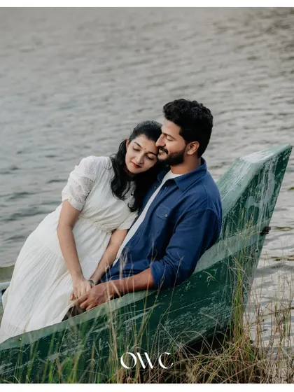 A romantic and peaceful portrait of a couple relaxing in a boat by the lakeshore.