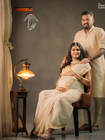 This wide shot shows the full setup for a traditional couple's maternity session. The warm lighting, classic furniture, and coordinated outfits come together to create a beautiful and cohesive story.