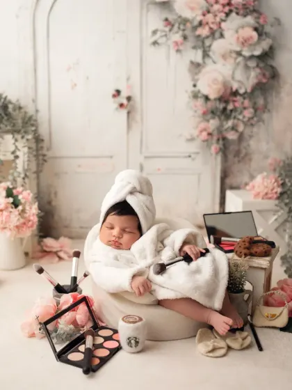 A wider view of the newborn spa day setup, showing the full, elaborate scene with floral arrangements and props.