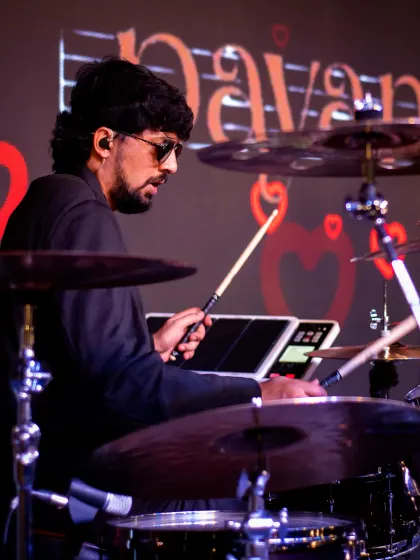 Our drummer keeps the rhythm moving, surrounded by cymbals and drums on the Mysuru stage.