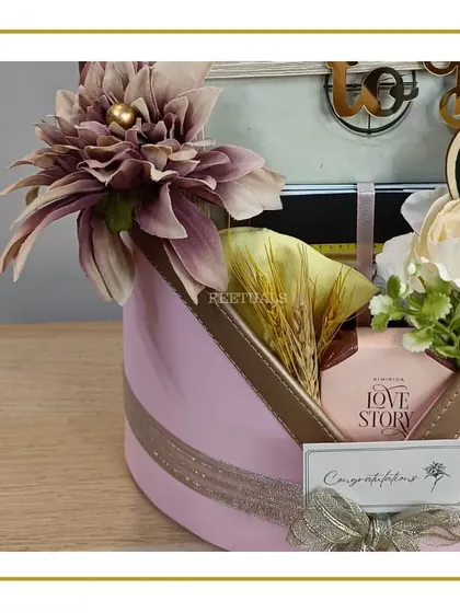 A side view of the elegant pink hat box hamper, showcasing the beautiful floral arrangement and the "Congratulations" gift tag.