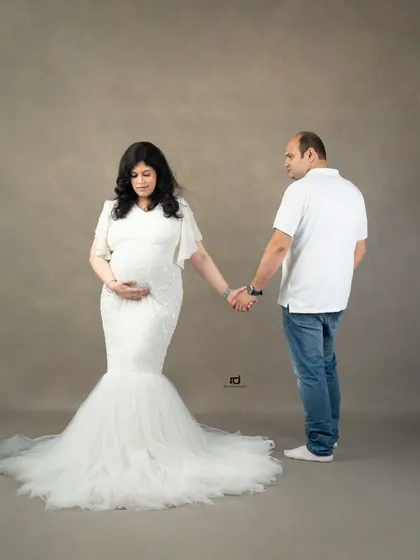 Holding hands, ready to walk into the future together. This full-length shot showcases the beautiful mermaid-style gown and the simple, strong connection between the couple.