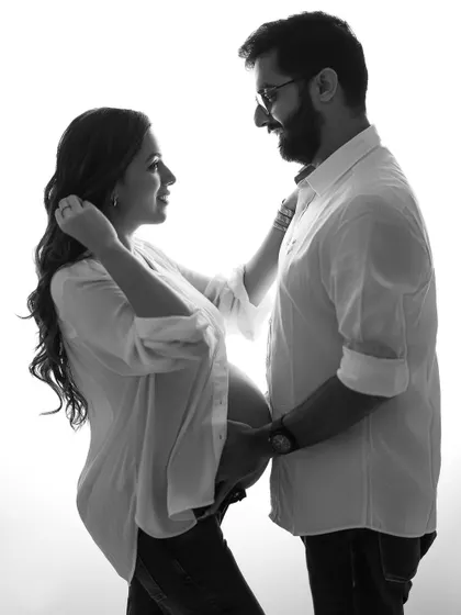 A full-length black and white portrait that feels both classic and modern. It captures their loving interaction and the excitement of starting their journey into parenthood.