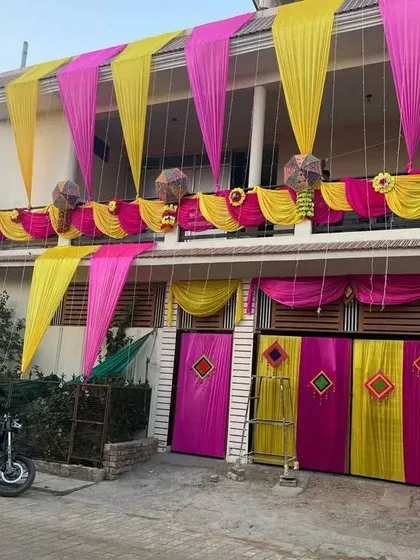 The same house decoration seen during the day, showcasing the vibrant pink and yellow fabric against the building's exterior.