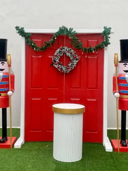 These classic life-size nutcracker props stand guard at a festive red door, creating a simple yet iconic Christmas scene.