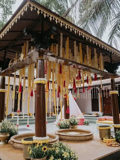 A wide shot of the Haldi ceremony area, featuring the central mandap with its hanging floral tassels and the cozy teepee-style seating areas on the side, creating a festive and relaxed atmosphere.