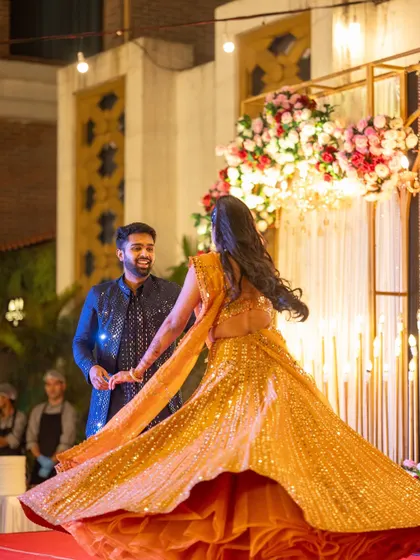 The bride's joyful twirl during her Sangeet performance. The stage lighting and backdrop are designed to enhance these key moments, making them truly cinematic.