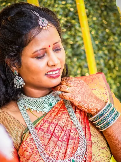 A candid portrait of the bride, glowing with happiness. The warm lighting and her gentle smile make this a beautiful, natural shot that captures her joy during the engagement ceremony.