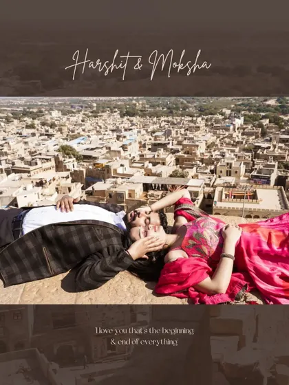 A unique aerial-view perspective of a couple relaxing on the ramparts of a Jaisalmer fort, with the sprawling golden city below them, blending history with a modern love story.