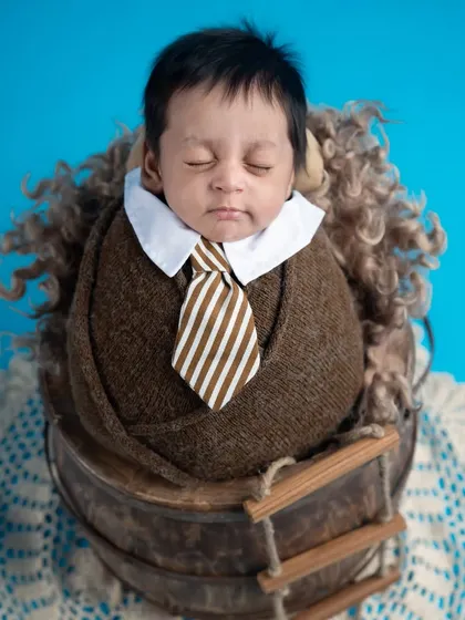 Dressed for success. This tiny gentleman in a wrap with a collar and tie is ready to take on the world, but first, a nap.