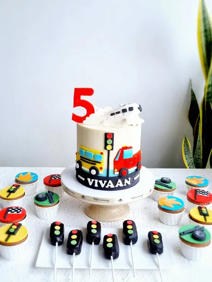 The full vehicle-themed dessert table, with the cake, cupcakes, and traffic light cakesicles.