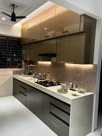 This is a great example of a functional kitchen layout. The dual-tone cabinets in a glossy finish, combined with a durable countertop and profile handles, create a modern and easy-to-maintain space for everyday cooking.
