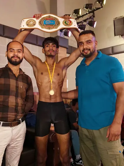 Holding the title belt high. This is the reward for all the blood and sweat shed in the gym.