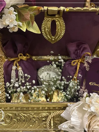 The Rajwada Chest is an ode to royal traditions. This exquisite hamper, with its deep purple velvet, intricate gold-finished metalwork, and curated treasures within, is crafted to add a touch of grandeur to your wedding celebrations.