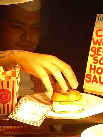 A chef serving up a delicious burger at one of my live stations. The focus is on fresh preparation and a fun, interactive experience for guests.