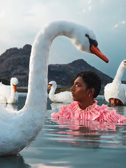 A surreal and serene composition from my 'KINNAR' series, exploring themes of grace and identity. This shoot blends high-fashion with fine art, styling a ruffled, vibrant garment to contrast with the natural tranquility of the water and swans.