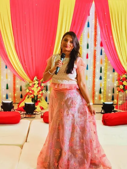 As an emcee, my job is to bring the party to life. Here I am, microphone in hand, hosting a lively Mehndi and Ganesh Pooja function. I ensure the event flows smoothly with engaging games and a vibrant atmosphere that gets everyone involved.