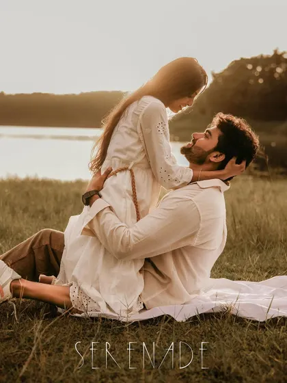 A romantic pre-wedding photo of a couple in a field at sunset, captioned "Serenade".