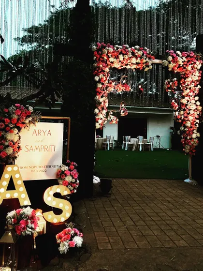 A personalized welcome entrance for a wedding reception. I created a lush floral arch and arranged flowers around the couple's initials in large marquee letters.
