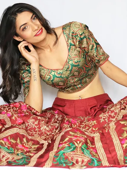 This outfit is a celebration of heritage, blending a traditional green Banarasi brocade blouse with a richly embroidered red raw silk skirt. It’s a smart ethnic lehenga that is perfect for a royal-themed wedding celebration.