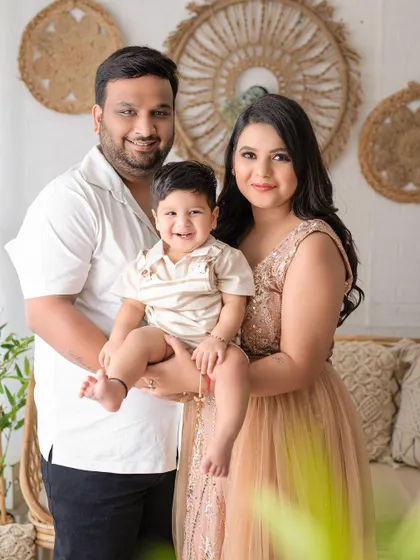 A classic family portrait against a bohemian-inspired backdrop. The family's smiles and relaxed poses show their genuine happiness.