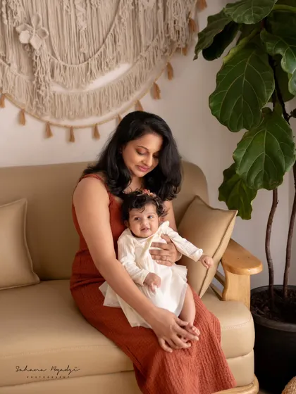 A mother and her baby girl in a cozy studio setting. The natural textures and warm colors create a comfortable and inviting atmosphere for this sweet portrait.