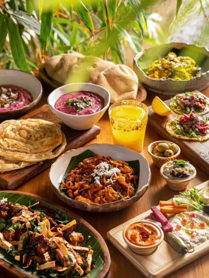 A beautiful flat lay of a Middle Eastern and Goan fusion spread at Kaia Goa. The natural light and variety of colorful dishes create an image of a bountiful, delicious feast.