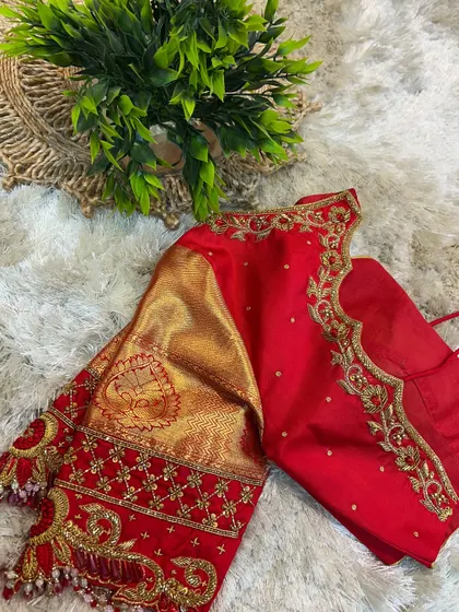 A side view of the red blouse, showing the intricate floral and paisley embroidery along the back and sleeves.