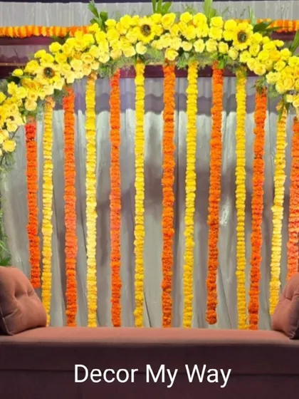 The classic marigold backdrop is a staple for many Indian ceremonies. Here, the arch and hanging garlands create a bright and auspicious setting, perfect for poojas or haldi functions.
