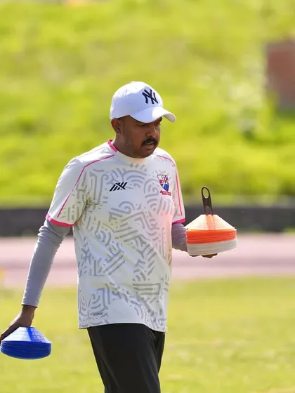 A coach carries cones off the field after a warm-up session. Our staff is hands-on, ensuring every detail is managed during our tours.