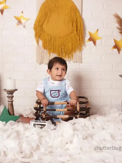 This little one is having fun playing with props in our cloud-filled, star-dusted bohemian studio.