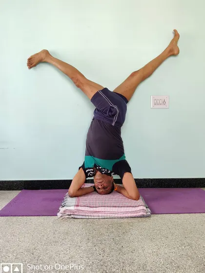 Parivrtta Eka Pada Shirshasana (Revolved One-Legged Headstand). This twisting variation in headstand requires immense core strength and a refined sense of balance.