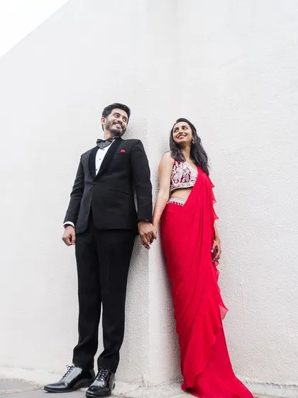 A stylish couple portrait, perfect for a Sangeet or reception, showcasing their coordinated outfits.