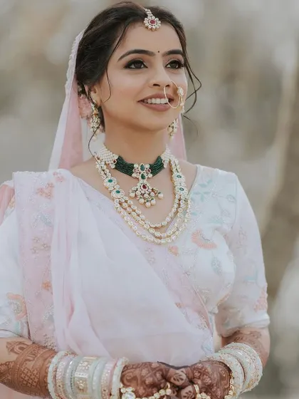 A soft and romantic updo with loose tendrils framing the face. This hairstyle gives a dreamy and ethereal vibe, perfect for a pastel-themed wedding.