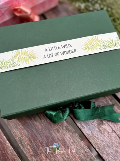 For a "Wild Adventure" theme, I used this deep forest green box with a custom sleeve that reads "A little wild, a lot of wonder," perfect for a nature-inspired baby boy gift.