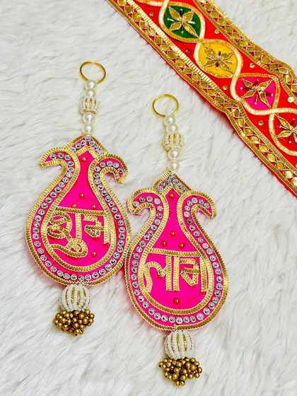 This paisley-shaped Shubh Labh latkan in bright pink and gold is a stylish way to decorate your home. The simple yet elegant design is perfect for modern tastes.