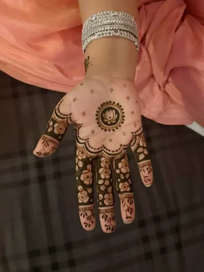 A beautiful floral mandala on the palm with filled-in fingers. This design is a perfect mix of traditional and minimalist styles.