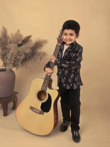 A bright, happy smile from our young musician. This shot captures his joyful personality and makes for a heartwarming and classic child portrait.
