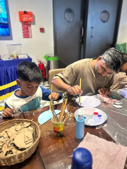 A father and son working together on a painting. Our Father's Day workshop was all about creating these special moments of connection and collaboration.