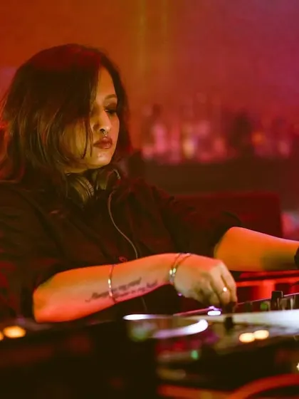 A focused shot of me mixing at i-Bar. The blurred background and warm lighting highlight the intensity and passion I put into every set, ensuring a quality house and tech house experience.