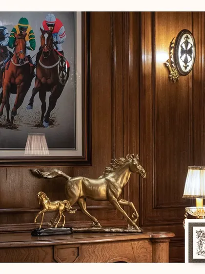 Elevate your space with the timeless elegance of equestrian art. This setting combines a stunning golden horse sculpture with a dynamic horse racing painting, creating a sophisticated and artful corner.