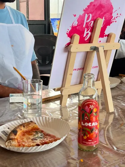 A slice of pizza and a cool drink, the perfect companions for a painting session. We believe creativity is fueled by good food and good vibes.