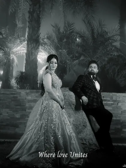 A timeless black and white portrait of the couple at their engagement venue. The dramatic lighting and their elegant attire create a cinematic feel.
