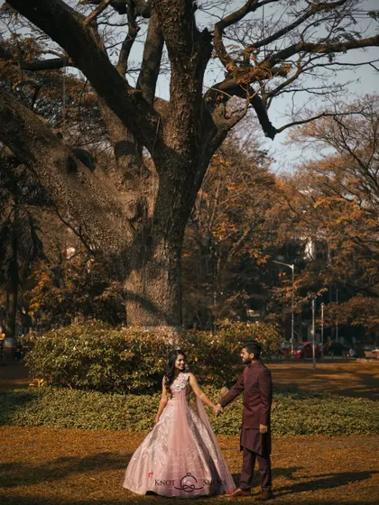 A wide shot showing the couple in a beautiful park setting. This type of environmental portrait captures not just the couple, but also the lovely atmosphere of their engagement session.