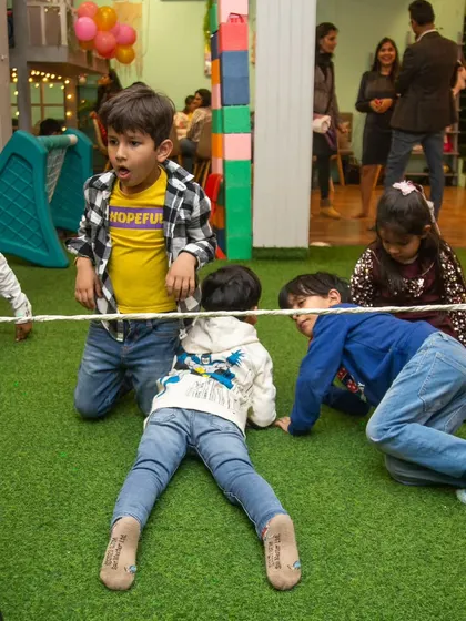 A group of boys carefully makes their way under the limbo rope. It's a game of concentration and fun for all ages.