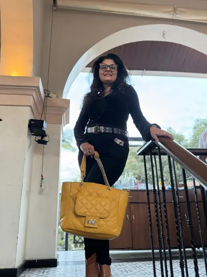 The same all-black outfit, but this time accessorized with a bright yellow handbag to add a pop of color.